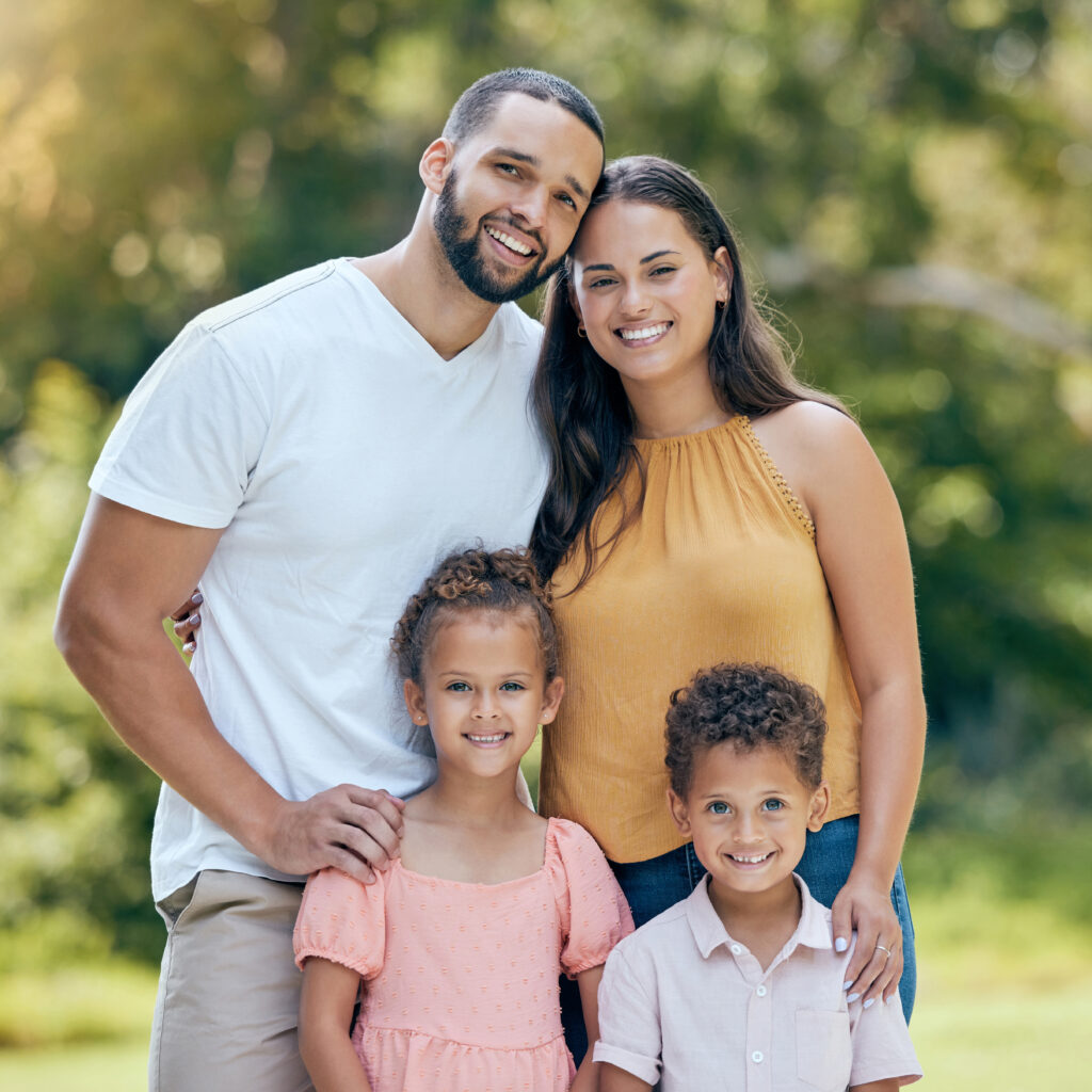 Smiling family of four enjoying time outdoors, representing the warmth and values of the Sudsies team.