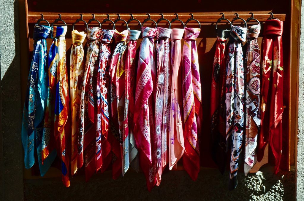 Image depicts a row of silk scarves