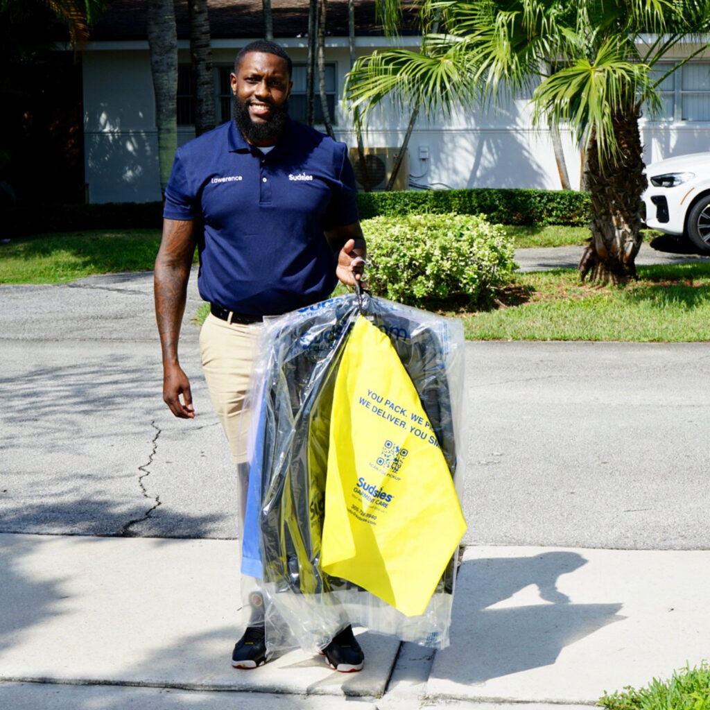 Sudsies garment care valet Lawrence holding a garment bag during pickup service
