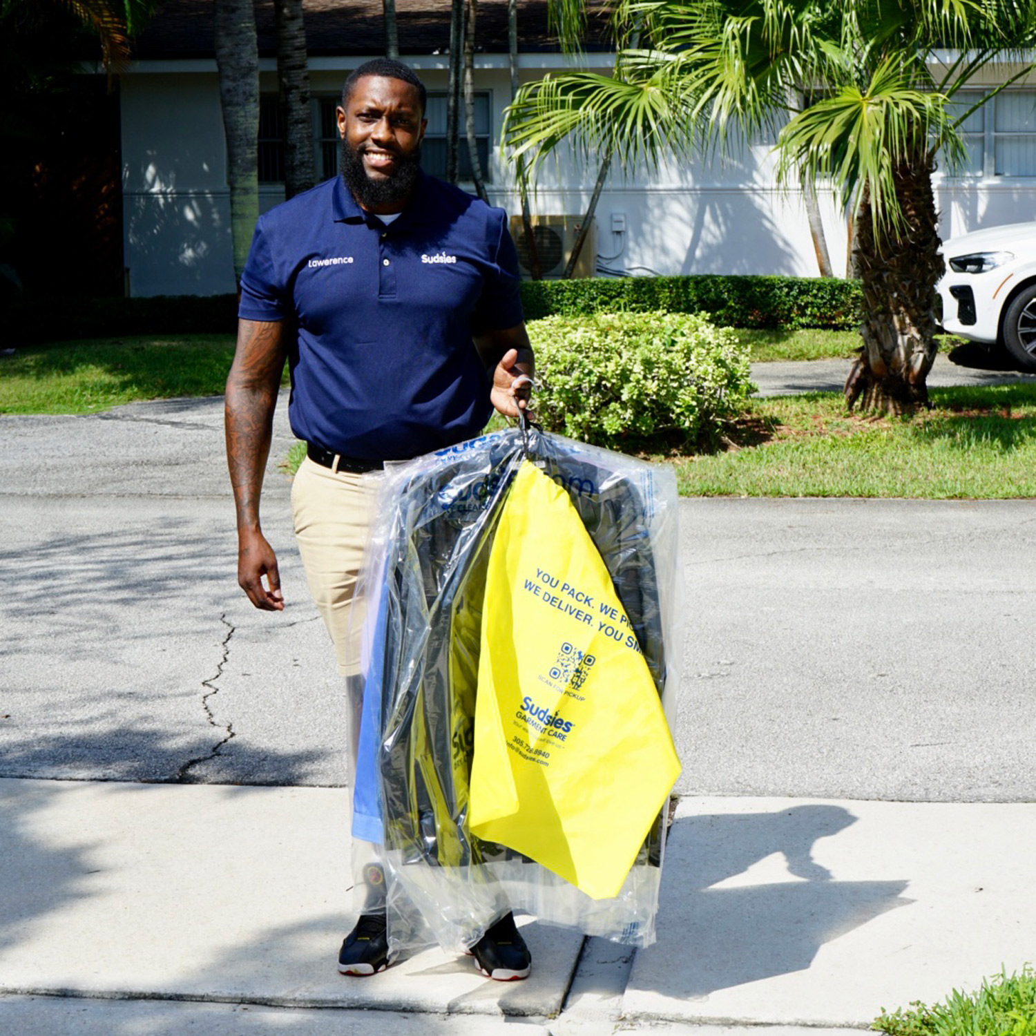 Sudsies garment care valet Lawrence holding a garment bag during pickup service