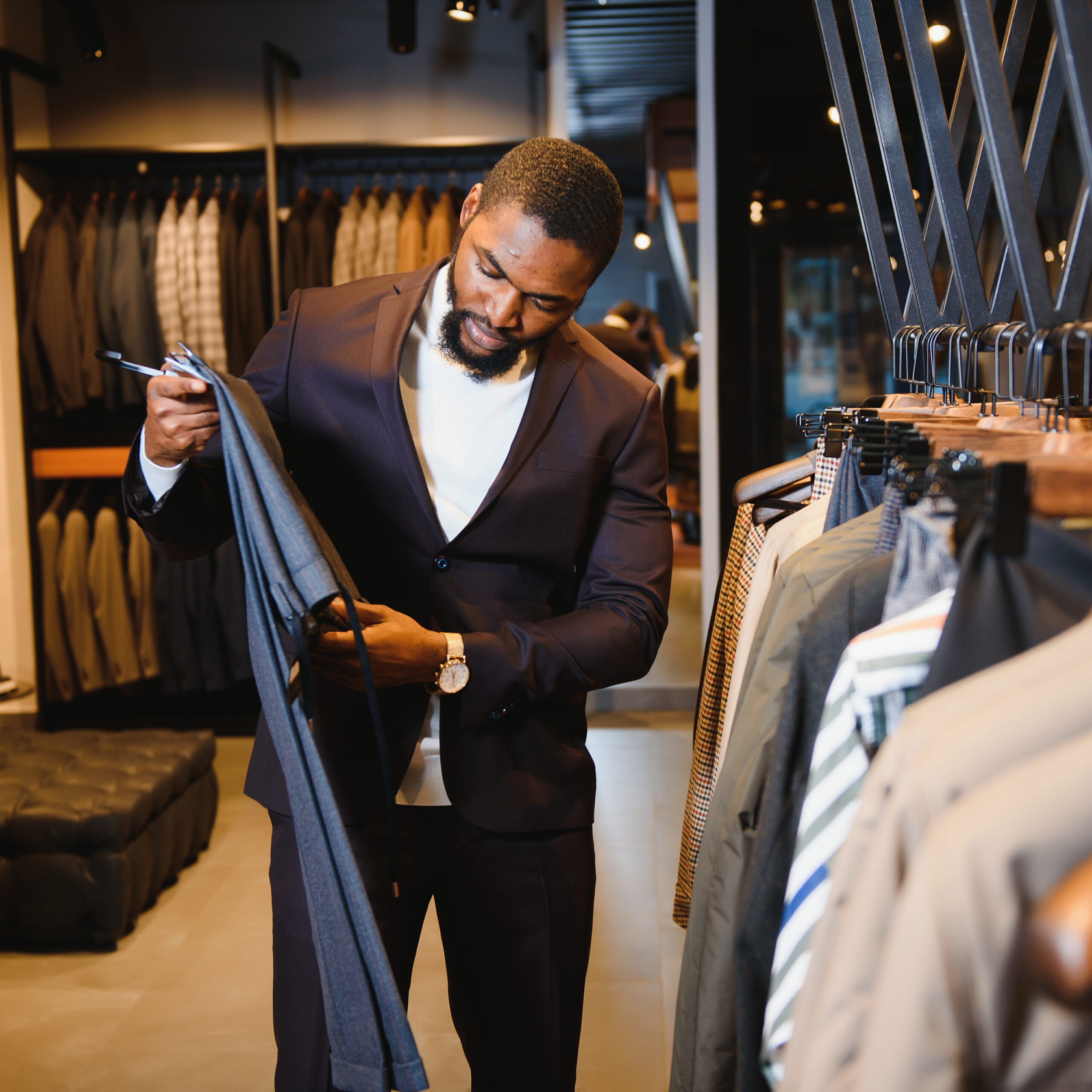 Man browsing luxury menswear, symbolizing premium care for designer garments