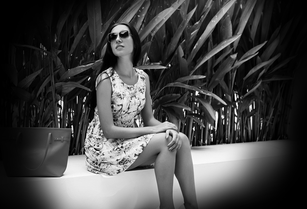 black and white model in front of plants