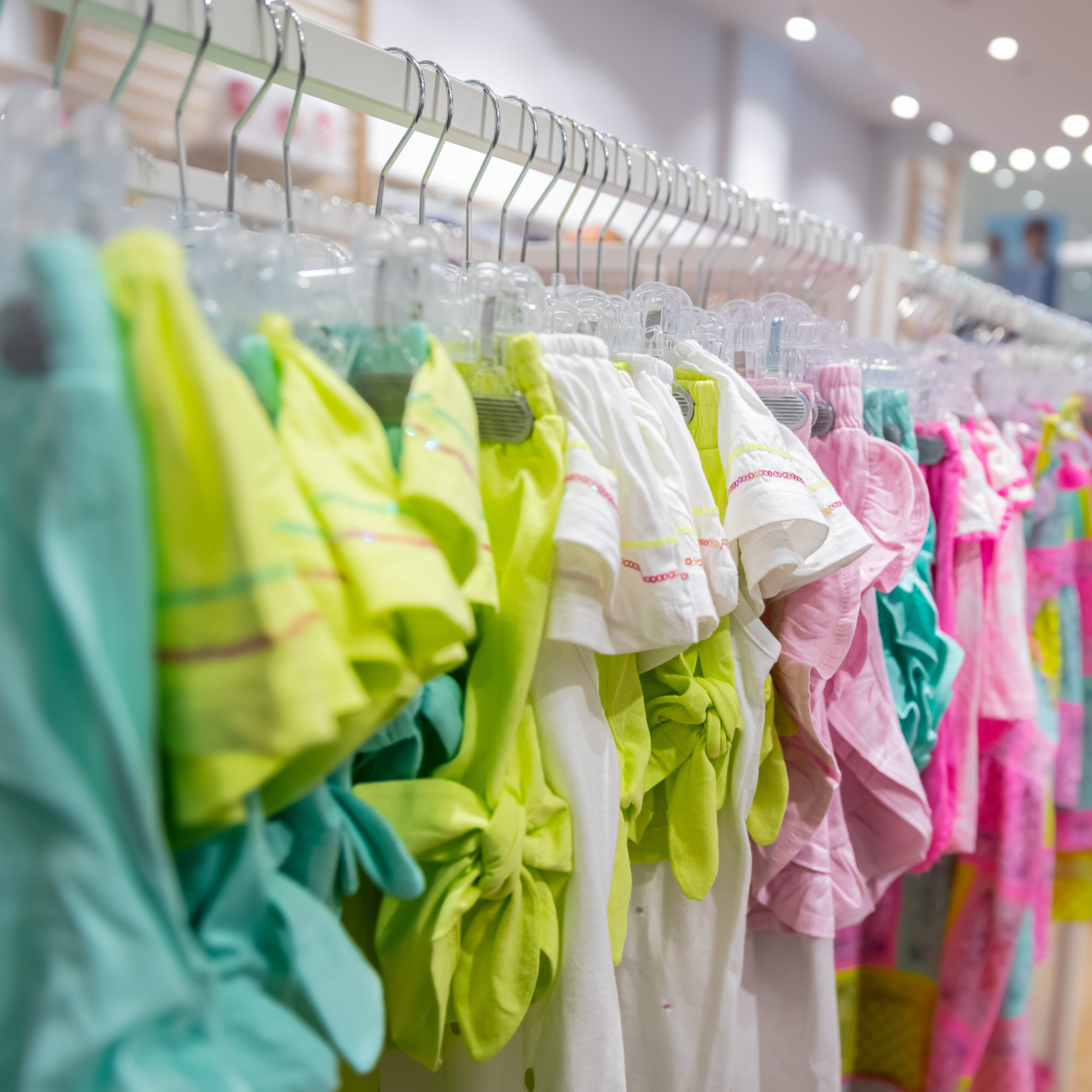 Colorful luxury children’s garments on hangers, representing Sudsies’ eco-friendly dry cleaning services for kids’ designer clothing in Miami and across the U.S.