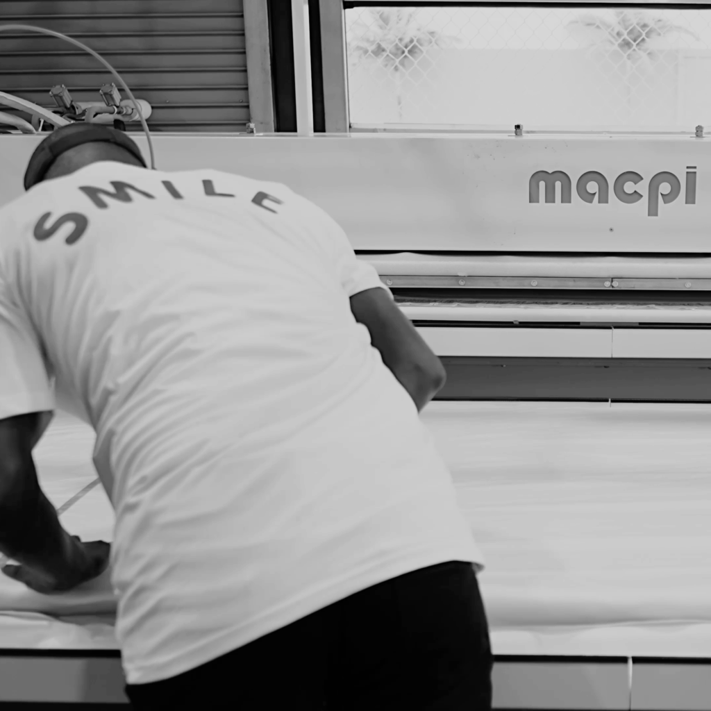 Sudsies technician operating MACPI garment finishing equipment with care in Fort Lauderdale