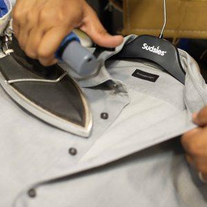 Close-up of a shirt being professionally pressed at Sudsies with careful attention to detail