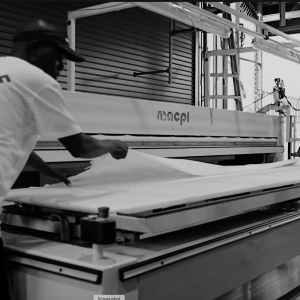 Sudsies technician operating MACPI sheet pressing equipment in Miami facility