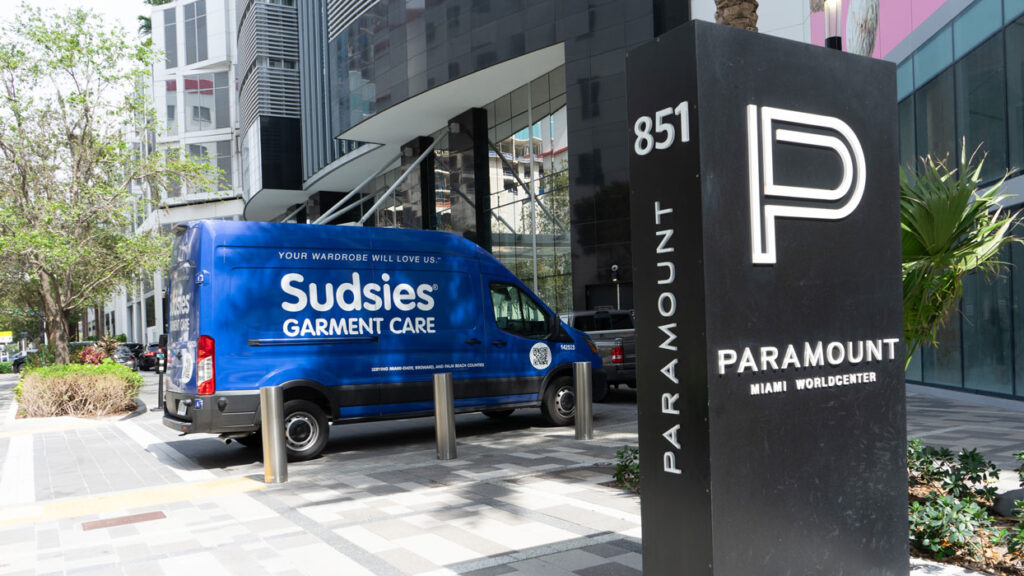 Sudsies garment care delivery van parked outside Paramount Miami Worldcenter, offering premium dry cleaning and concierge service in downtown Miami.