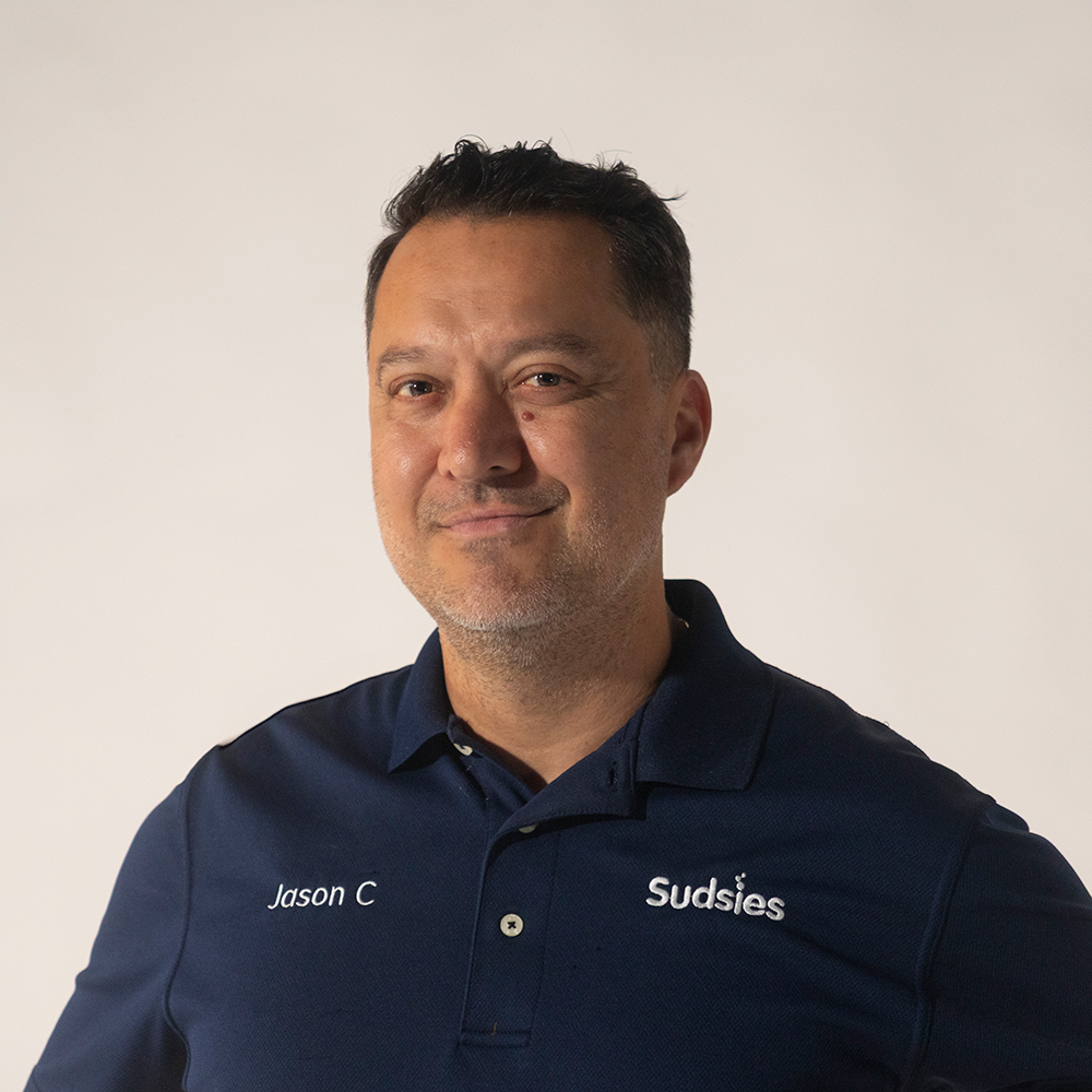 Portrait of Jason Cespedes, Vice President of Customer Relations at Sudsies in a Sudsies Uniform