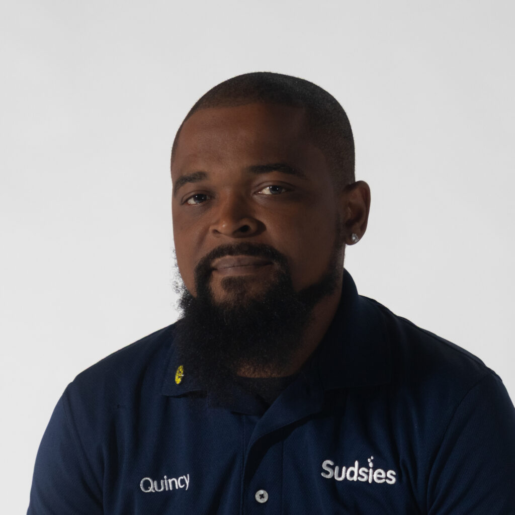 Portrait of Quincy Ferguson, Communities Guest Services team member at Sudsies.