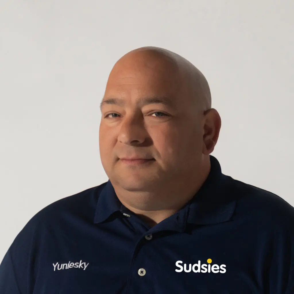 Portrait of Yuniesky, Sudsies garment care team member in uniform.