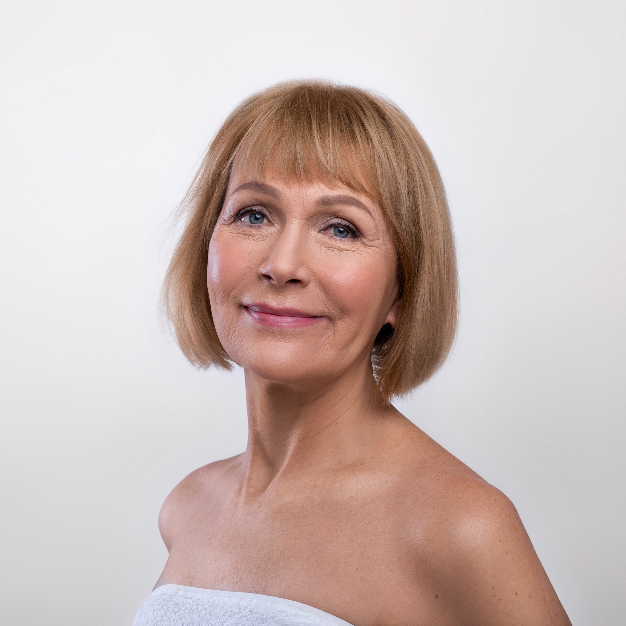 Refined senior woman smiling gracefully in elegant portrait, symbolizing luxury dry cleaning services in Bal Harbour, Fisher Island, and Edgewater