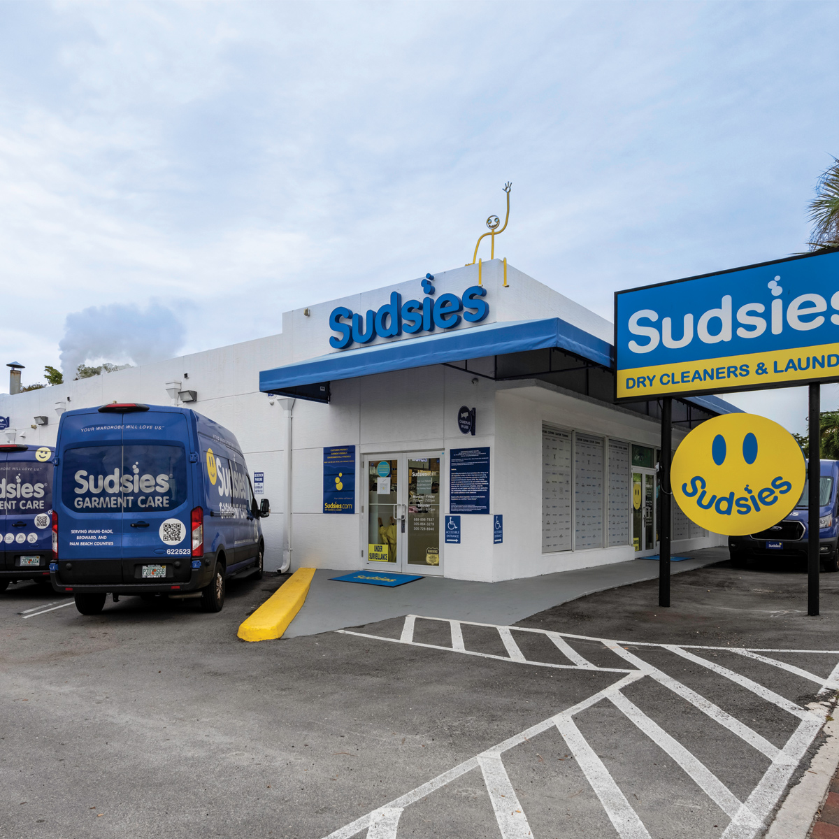Sudsies North Miami dry cleaners with branded delivery vans and storefront signage on Biscayne Boulevard