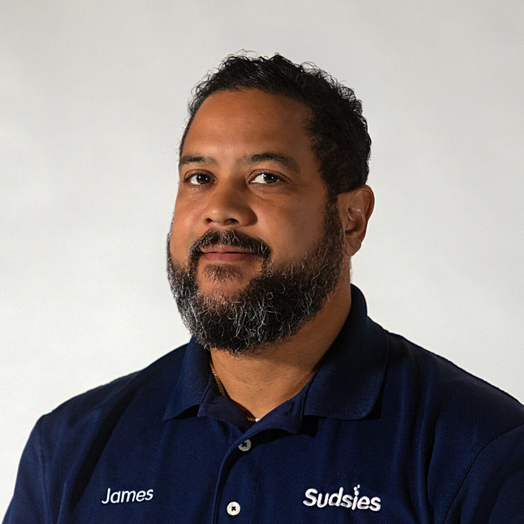 James Slater – Marketing Production Manager at Sudsies | Sudsies James Slater in navy Sudsies uniform with light grey backdrop