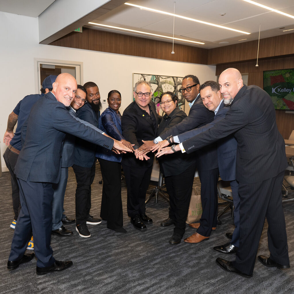 Sudsies team members stacking hands together in a conference room
