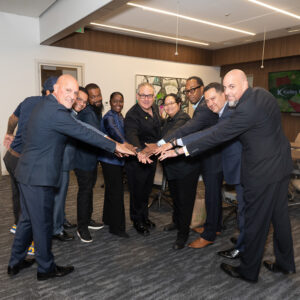 Sudsies team members stacking hands together in a conference room