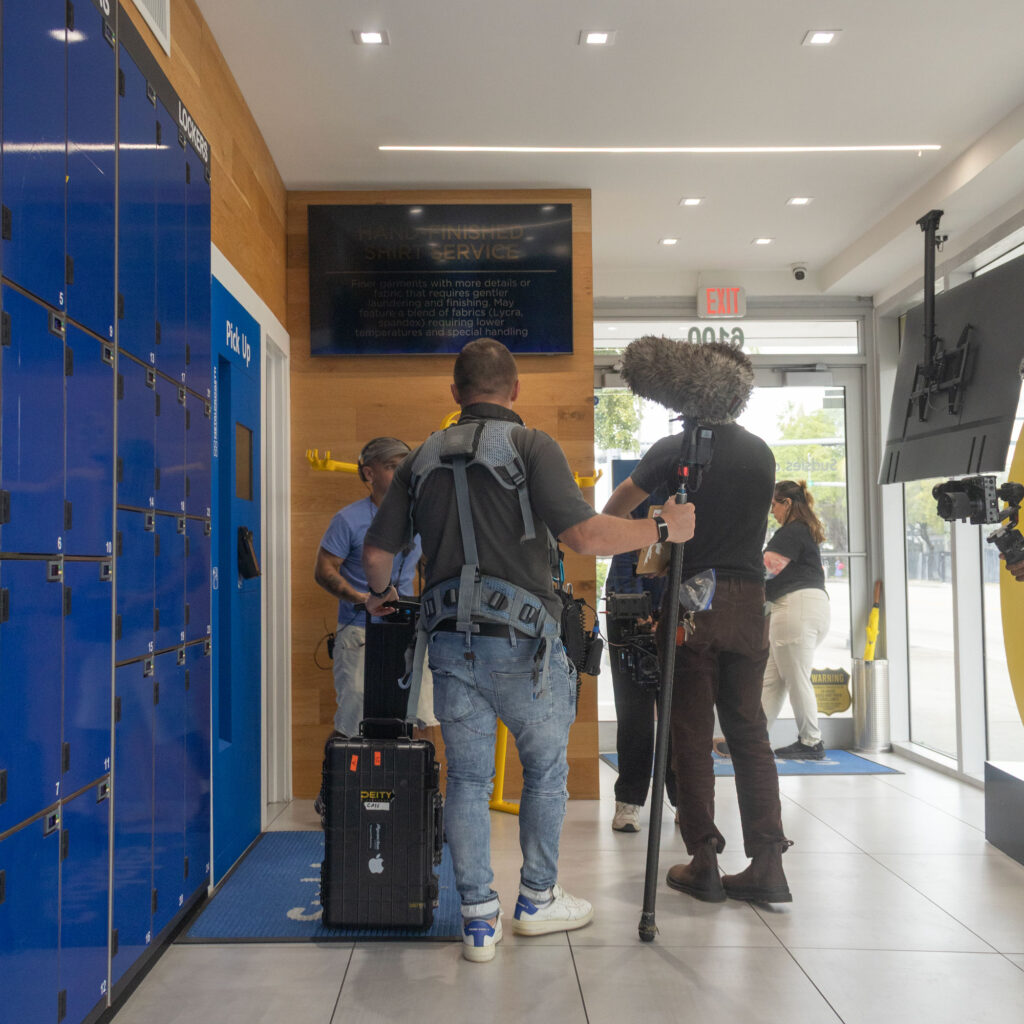 Film crew capturing behind-the-scenes footage inside the Sudsies Design District boutique