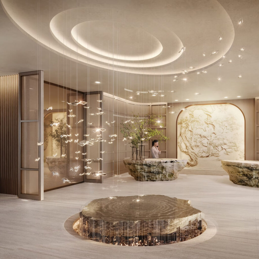 The Sudsies lobby inside the Rivani Miami Beach building, featuring sculptural stone reception desks, curved architectural lighting, and a modern art installation suspended above a circular stone centerpiece.