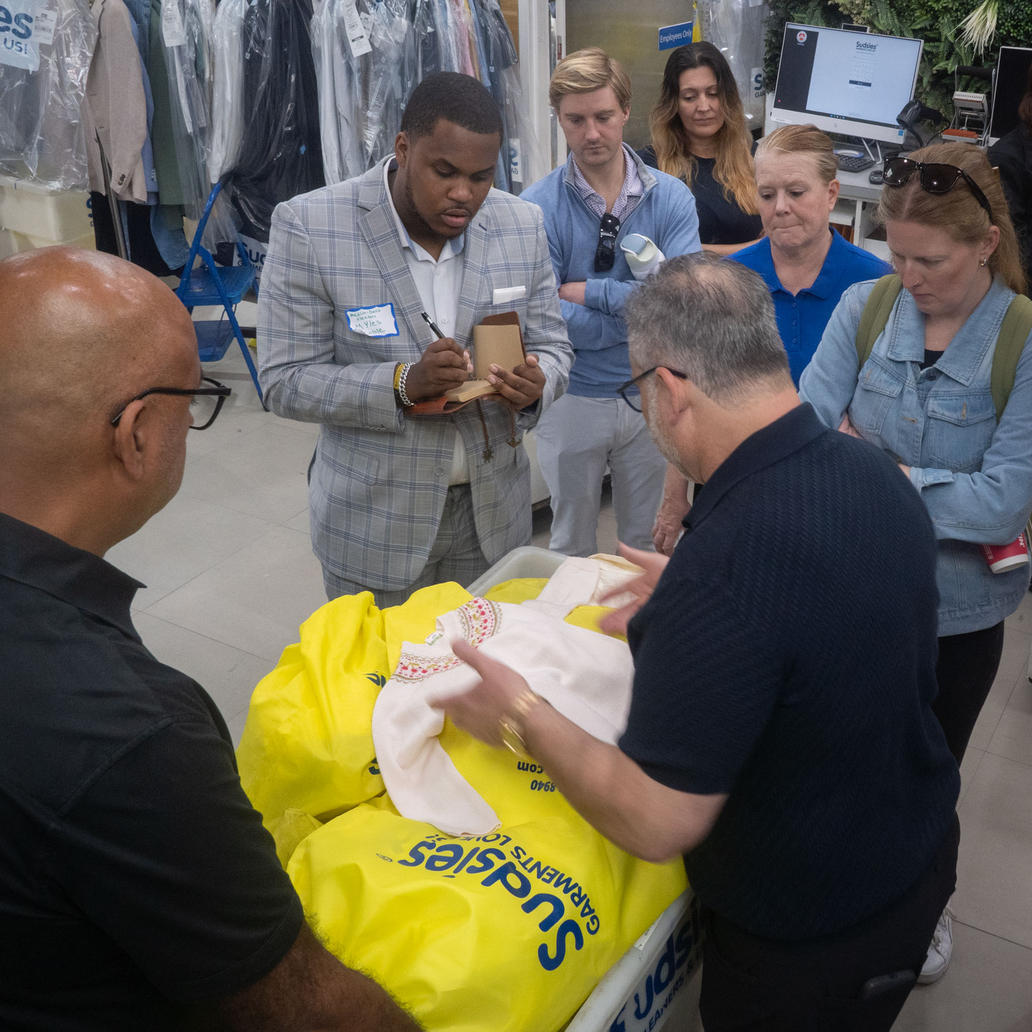 Sudsies team demonstrating garment inspection and care techniques during hands-on training session