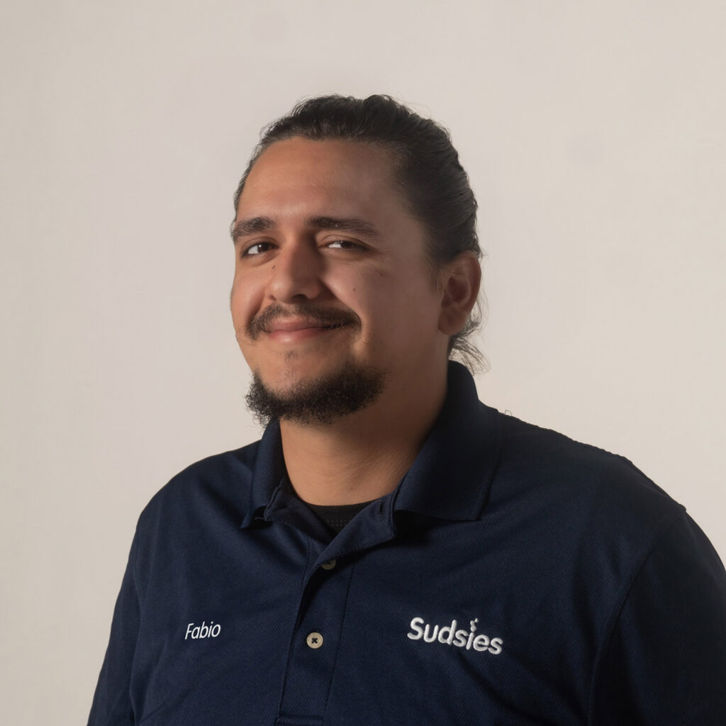 Fabio Sudsies garment care valet wearing navy uniform smiling portrait