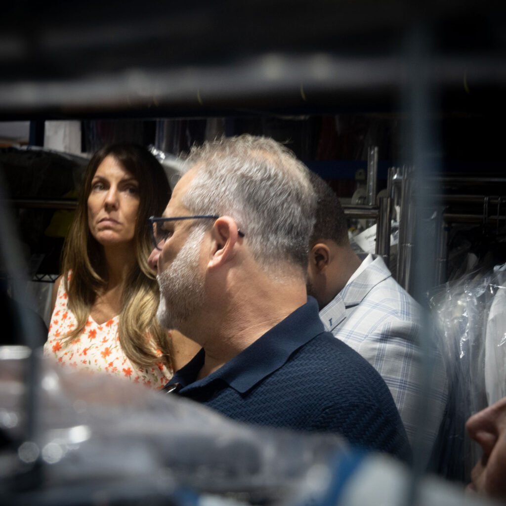 Sudsies leadership team reviewing garments and discussing dry cleaning operations in facility