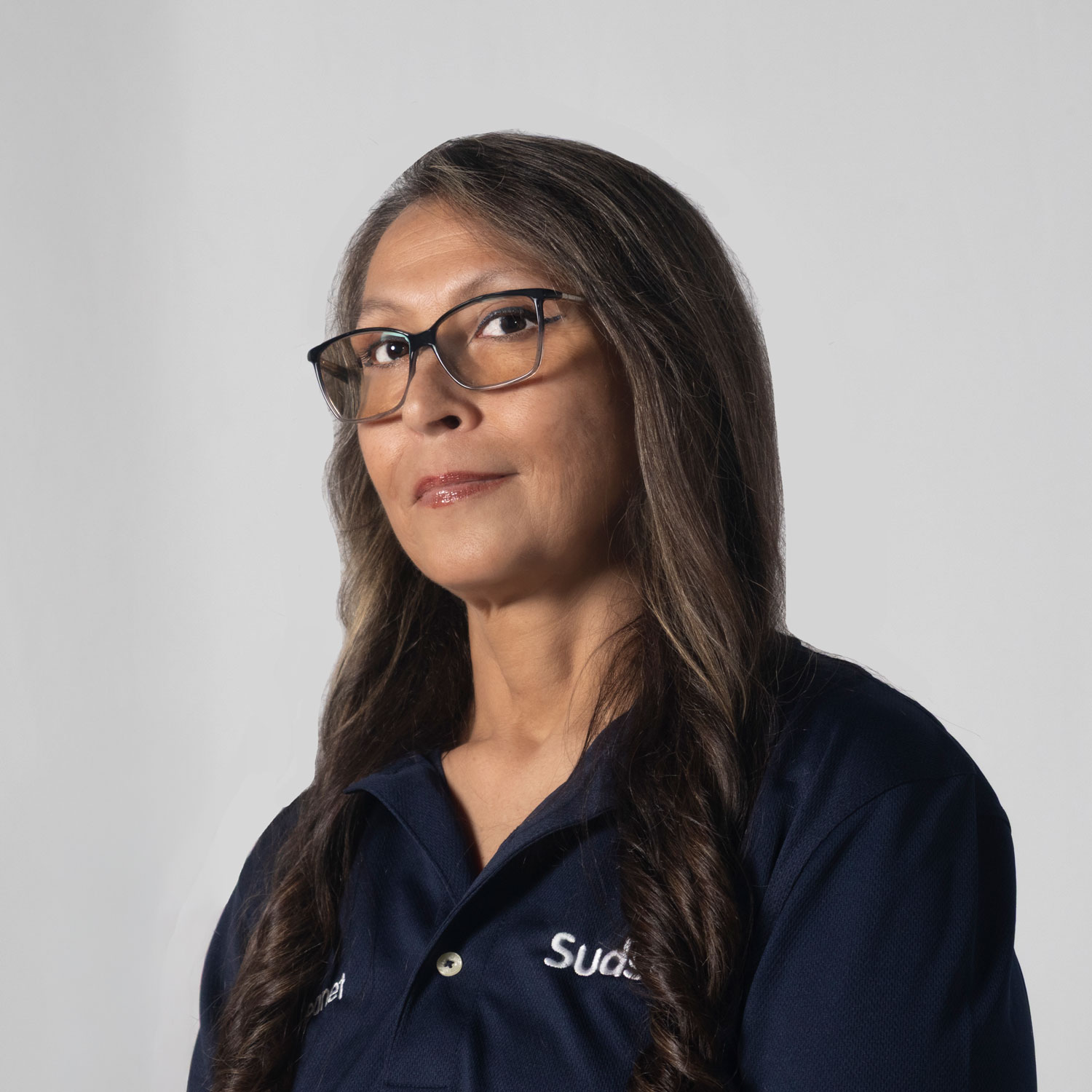 Jeanet from Sudsies wearing navy uniform during professional portrait for Route 74 pickup and delivery garment care service.