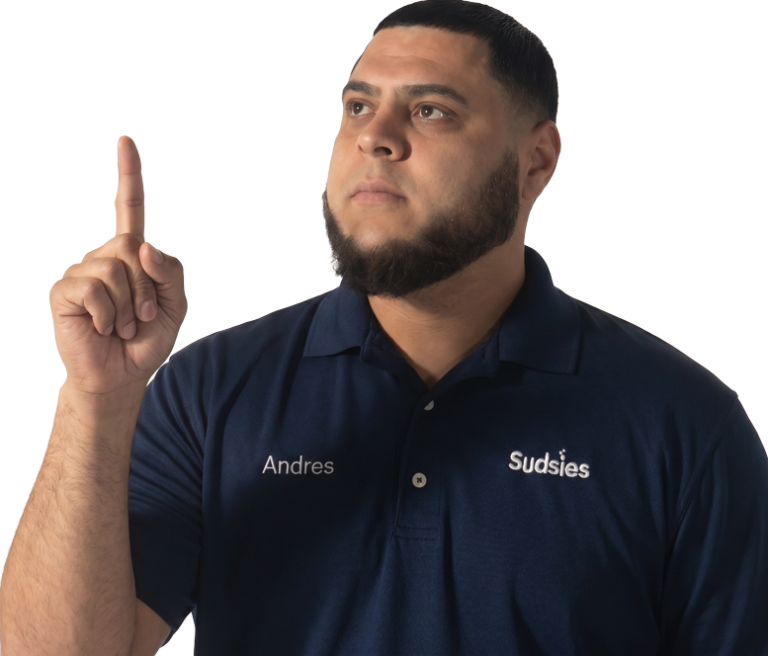 Sudsies garment care valet Andres wearing a navy branded polo while pointing upward against a transparent background.