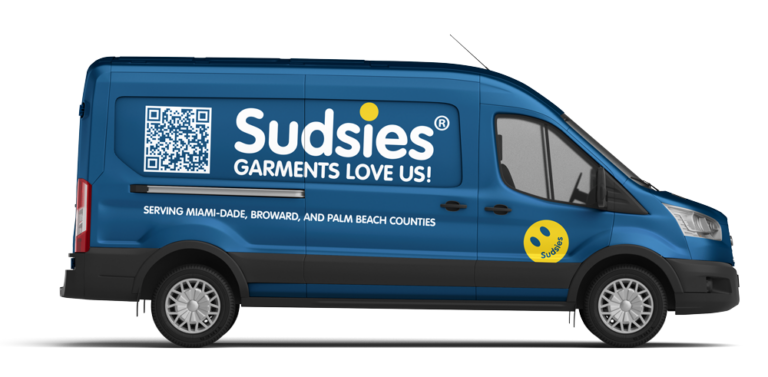 Passenger-side view of a blue Sudsies pickup and delivery van featuring branded graphics, QR code, and South Florida service coverage.