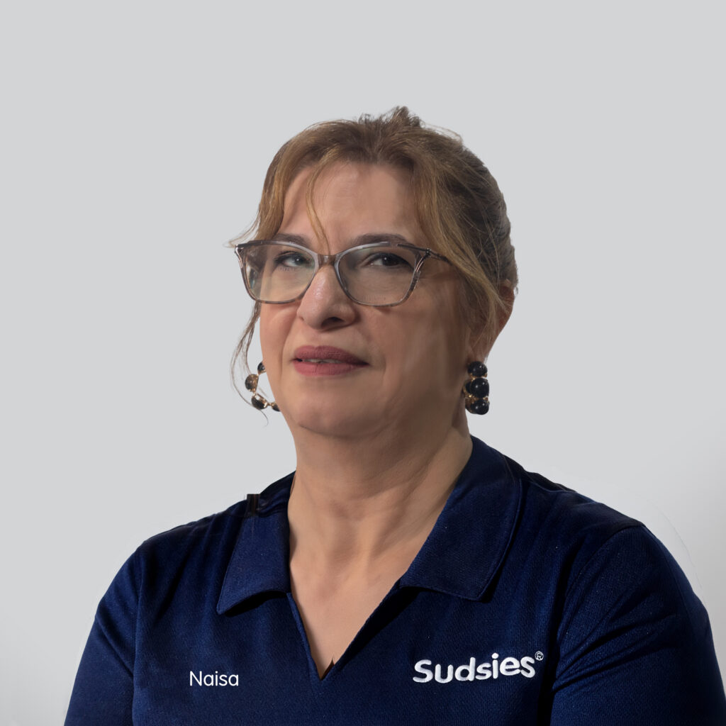 Portrait of Naisa, a Sudsies seamstress, wearing a navy Sudsies uniform in the alterations department.