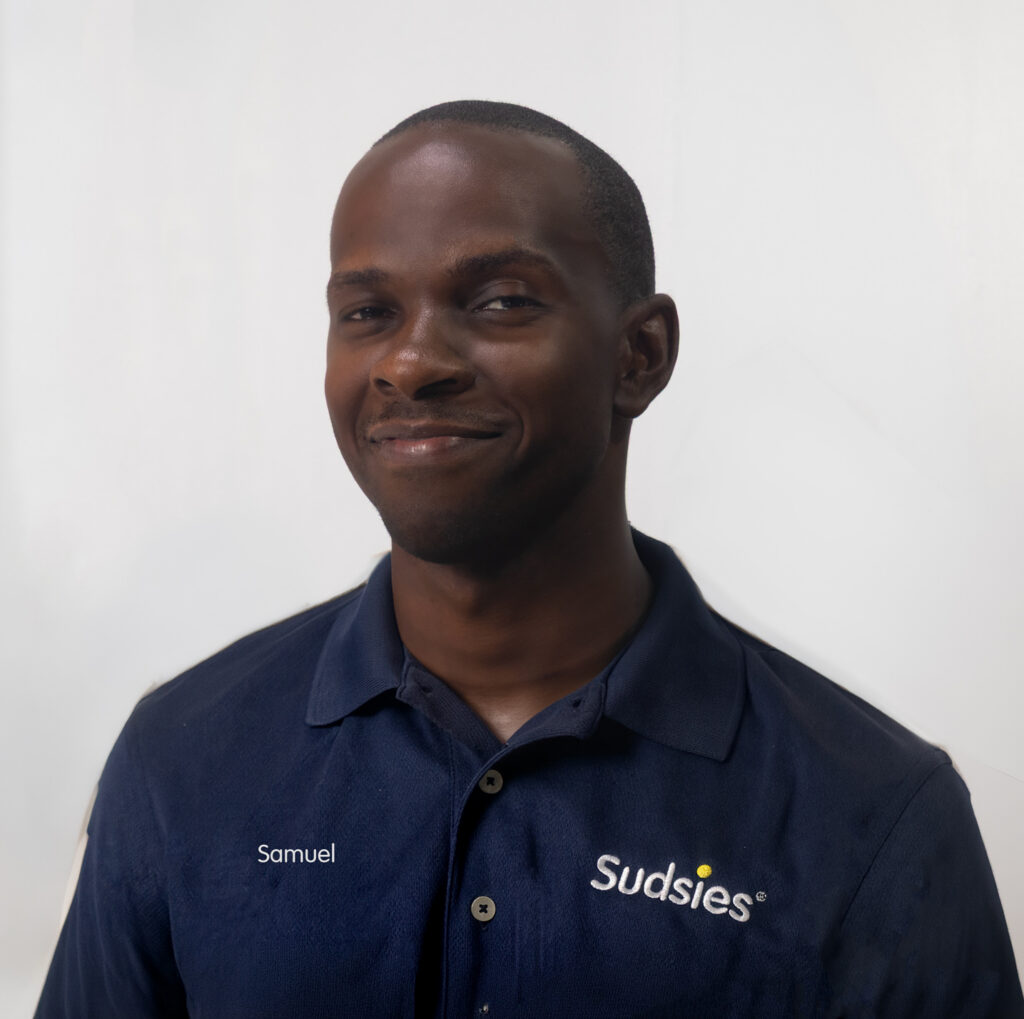 Portrait of Samuel, a Sudsies Customer Service Representative, wearing a navy Sudsies uniform in a studio setting.